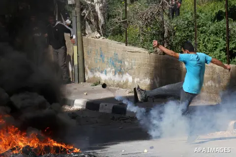 A Palestinian protester kicks a tear gas canister fired by Israeli security forces during clashes in the village of Araka, West of Jenin in the Israeli occupied West Bank on February 15, 2016. Photo by Nedal Eshtayah