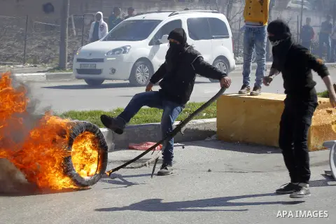 Palestinian protesters burn tires during clashes with Israeli security forces (unseen) to show solidarity with Mohammed al-Qiq a Palestinian prisoner on hunger strike, in the West bank city of Hebron on February 19, 2016...