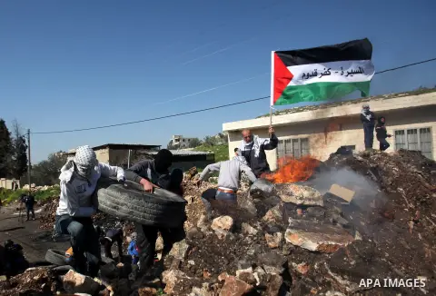 Palestinian protesters burn tires during clashes with Israeli security forces following a demonstration against the expropriation of Palestinian land by Israel on February 19, 2016 in the village of Kfar Qaddum, near Nab...