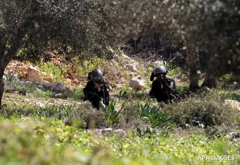 Israeli security forces aim their weapons towards Palestinian protesters during clashes following a demonstration against the expropriation of Palestinian land by Israel on February 19, 2016 in the village of Kfar Qaddum...