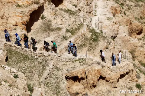 Palestinian youths walk on the mountains of Wadi Qelt, near the West Bank city of Jericho, on Feb 20, 2016. Wadi Qelt is a valley running west to east across the Judean desert in the West Bank, originating near Jerusalem...