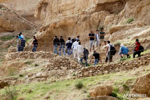 Palestinian youths walk on the mountains of Wadi Qelt, near the West Bank city of Jericho, on Feb 20, 2016. Wadi Qelt is a valley running west to east across the Judean desert in the West Bank, originating near Jerusalem...
