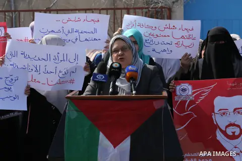 Palestinian women hold posters bearing a portrait of Palestinian journalist Mohammed al-Qiq who is imprisoned in an Israeli jail during a protest in support of his hunger strike in Gaza city on Feb. 21, 2016. Photo by Mo...