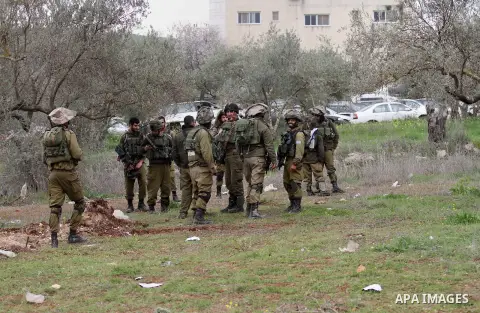Israeli soldiers secure the scene after a Palestinian man who tried to stab an Israeli soldier before being shot dead, at the Bitot Junction south of Nablus in the northern occupied West Bank, on February 21, 2016. "A Pa...
