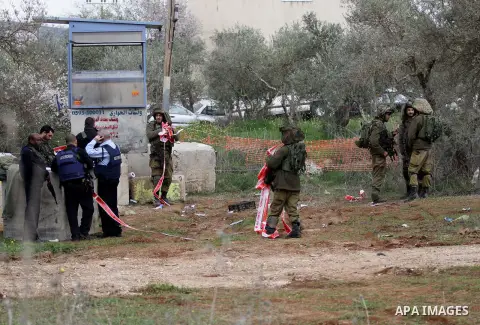 Israeli soldiers secure the scene after a Palestinian man who tried to stab an Israeli soldier before being shot dead, at the Bitot Junction south of Nablus in the northern occupied West Bank, on February 21, 2016. "A Pa...
