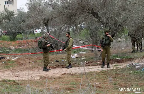Israeli soldiers secure the scene after a Palestinian man who tried to stab an Israeli soldier before being shot dead, at the Bitot Junction south of Nablus in the northern occupied West Bank, on February 21, 2016. "A Pa...