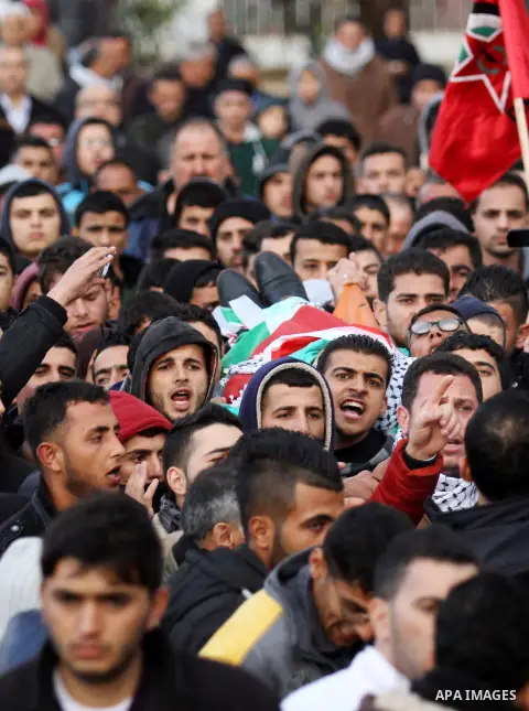 Mourners carry the the body of Palestinian teenager Qusay Abo Alrob, 16, whom the Israeli military said was shot dead by Israeli troops after he tried to stab a soldier on Sunday, during his funeral in the West Bank town...