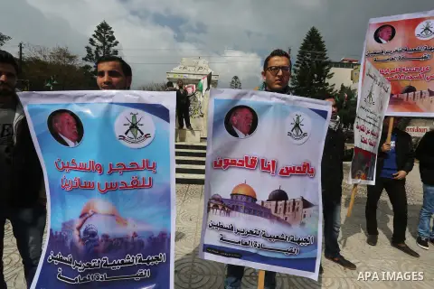 Palestinians hold posters bearing a portrait of Palestinian journalist Mohammed al-Qiq who is imprisoned in an Israeli jail during a protest in support of his hunger strike in Gaza city on Feb. 23, 2016. Photo by Mohamme...