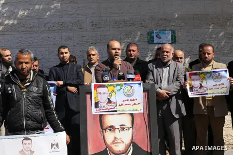 Palestinian journalists hold posters bearing a portrait of Palestinian journalist Mohammed al-Qiq who is imprisoned in an Israeli jail during a protest in support of his hunger strike in front of Red Cross office, in Gaz...