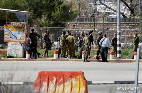 Israeli soldiers gather at the scene of an attack at the Gush Etzion junction in the West Bank, Wednesday, Feb. 24, 2016. The Israeli military says a knife-wielding Palestinian rushed toward an Israeli in the West Bank a...
