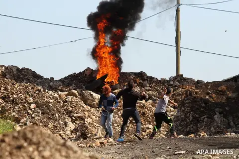 Palestinian protesters hurl stones toward Israeli security forces during clashes following a protest against the expropriation of Palestinian land by Israel in the West Bank village of Kafr Qaddum, near the northern city...