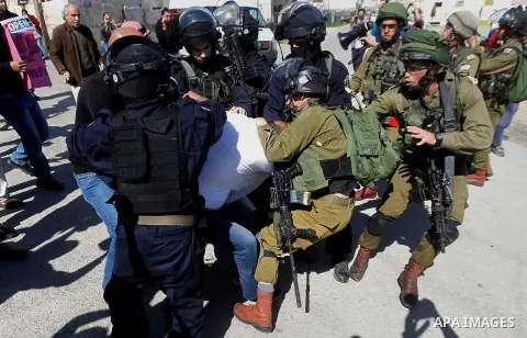 Israeli soldiers and border police detain a Palestinian protester during a demonstration against the closure of Shuhada street to Palestinians, on the 22nd anniversary of the closure, in the West Bank city of Hebron Febr...