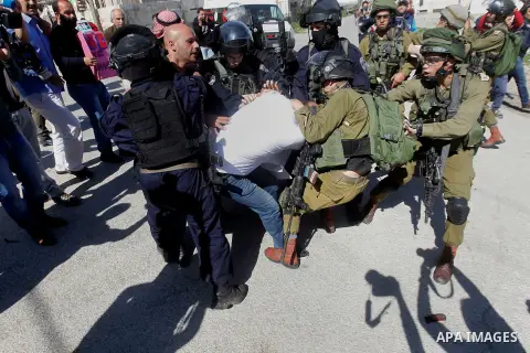 Israeli soldiers and border police detain a Palestinian protester during a demonstration against the closure of Shuhada street to Palestinians, on the 22nd anniversary of the closure, in the West Bank city of Hebron Febr...
