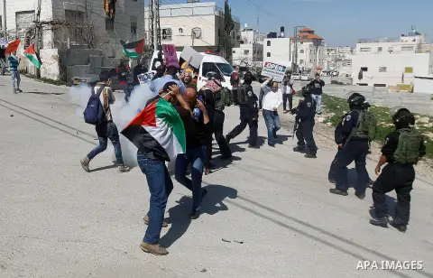 Palestinian protesters hold banners during a demonstration against the closure of Shuhada street to Palestinians, on the 22nd anniversary of the closure, in the West Bank city of Hebron February 26, 2016. Photo by Wisam...