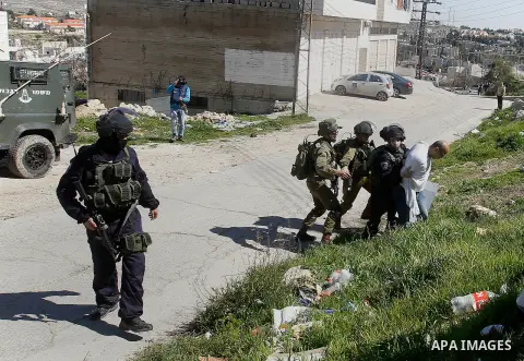 Israeli soldiers and border police detain a Palestinian protester during a demonstration against the closure of Shuhada street to Palestinians, on the 22nd anniversary of the closure, in the West Bank city of Hebron Febr...