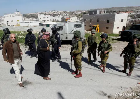 A Palestinian man scuffles with an Israeli border police during a demonstration against the closure of Shuhada street to Palestinians, on the 22nd anniversary of the closure, in the West Bank city of Hebron February 26,...