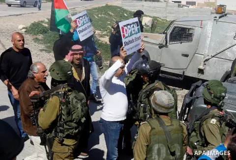 Palestinian protesters hold banners during a demonstration against the closure of Shuhada street to Palestinians, on the 22nd anniversary of the closure, in the West Bank city of Hebron February 26, 2016. Photo by Wisam...