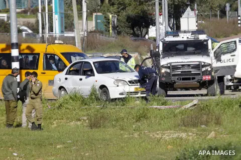 Israeli security forces inspect a car used by a Palestinian woman who, the Israeli military said, rammed it into an Israeli soldier before she was shot dead by the Israeli troops, at a main junction near the Israeli sett...