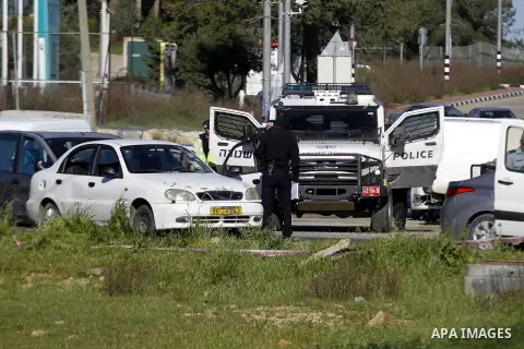 Israeli security forces inspect a car used by a Palestinian woman who, the Israeli military said, rammed it into an Israeli soldier before she was shot dead by the Israeli troops, at a main junction near the Israeli sett...