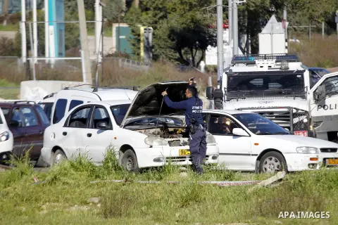 Israeli security forces inspect a car used by a Palestinian woman who, the Israeli military said, rammed it into an Israeli soldier before she was shot dead by the Israeli troops, at a main junction near the Israeli sett...