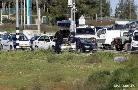 Israeli security forces inspect a car used by a Palestinian woman who, the Israeli military said, rammed it into an Israeli soldier before she was shot dead by the Israeli troops, at a main junction near the Israeli sett...