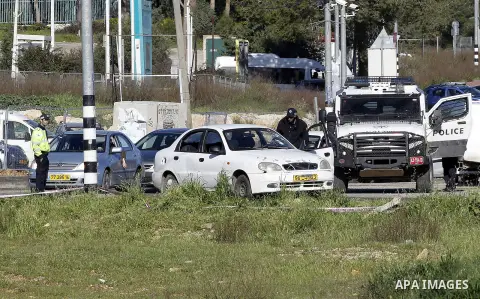 Israeli security forces inspect a car used by a Palestinian woman who, the Israeli military said, rammed it into an Israeli soldier before she was shot dead by the Israeli troops, at a main junction near the Israeli sett...