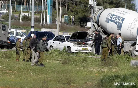 Israeli security forces inspect a car used by a Palestinian woman who, the Israeli military said, rammed it into an Israeli soldier before she was shot dead by the Israeli troops, at a main junction near the Israeli sett...