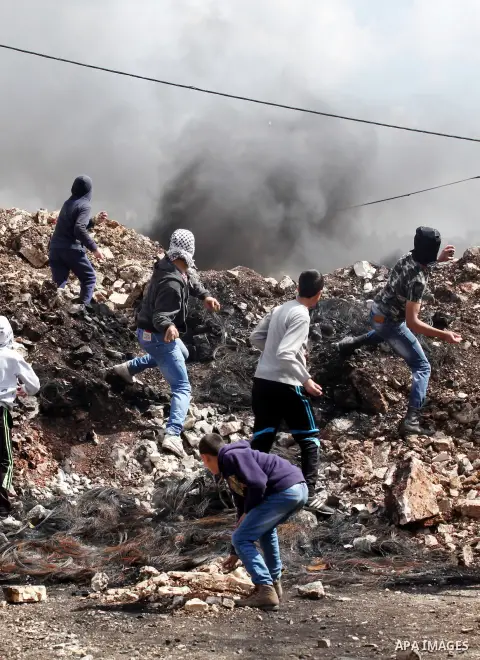 Palestinian protesters hurl stones towards Israeli security forces during clashes following a demonstration against the expropriation of Palestinian land by Israel in the village of Kfar Qaddum, near Nablus, in the occup...