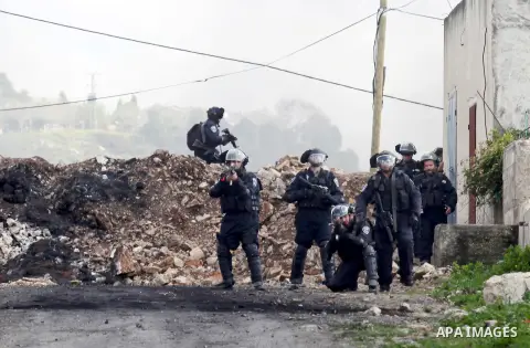 Israeli security forces aim their weapons towards Palestinian protesters during clashes following a demonstration against the expropriation of Palestinian land by Israel in the village of Kfar Qaddum, near Nablus, in the...