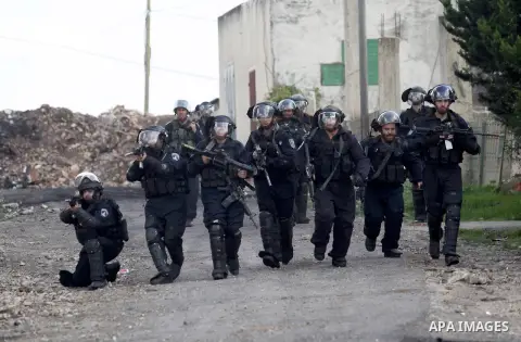 Israeli security forces aim their weapons towards Palestinian protesters during clashes following a demonstration against the expropriation of Palestinian land by Israel in the village of Kfar Qaddum, near Nablus, in the...