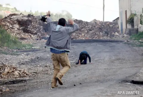 A Palestinian man rushes towards a boy who was injured during clashes with Israeli security forces following a demonstration against the expropriation of Palestinian land by Israel, in the village of Kfar Qaddum, near Na...