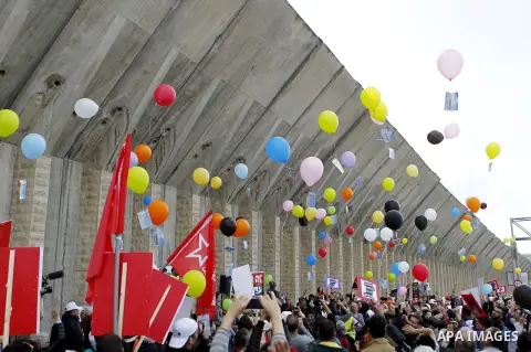Peace activists let go balloons along the Israeli controvertial separation wall during a joint Israeli-Palestinian peace march in the West Bank city of Beit Jala between Bethlehem and Jerusalem, on March 4, 2016. Peace a...