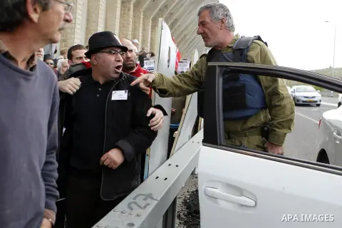 Peace activists argue with a member of Israeli security forces during a joint Israeli-Palestinian peace march along the Israeli controvertial separation wall in the West Bank city of Beit Jala between Bethlehem and Jerus...
