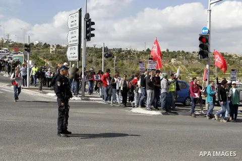 Peace activists hold placards during a joint Israeli-Palestinian peace march along the Israeli controvertial separation wall in the West Bank city of Beit Jala between Bethlehem and Jerusalem, on March 4, 2016. Peace act...