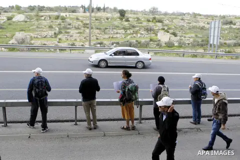 Peace activists hold placards during a joint Israeli-Palestinian peace march along the Israeli controvertial separation wall in the West Bank city of Beit Jala between Bethlehem and Jerusalem, on March 4, 2016. Peace act...