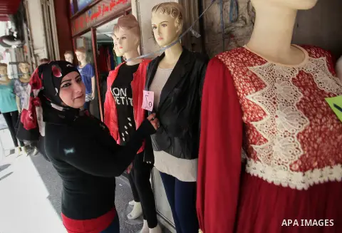 A Palestinian woman sells clothes at a shop, in the West Bank city of Nablus, on March 8, 2016. People around the globe celebrate International Women's Day, which dates back to the beginning of the 20th Century and has b...