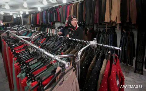 A Palestinian woman sells clothes at a shop, in the West Bank city of Nablus, on March 8, 2016. People around the globe celebrate International Women's Day, which dates back to the beginning of the 20th Century and has b...