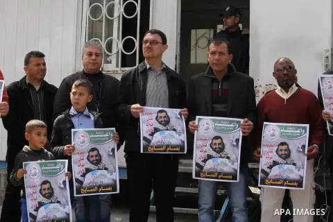 Palestinians hold placards during a protest in solidarity with Palestinian prisoners in Israeli jails, in front of high commissioner for human rights headquarters, in Gaza City on March 9, 2016. Photo by Mohammed Asad