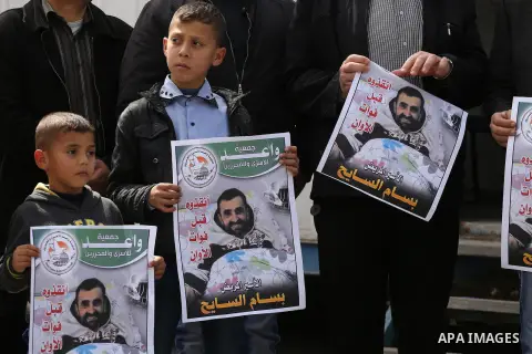 Palestinians hold placards during a protest in solidarity with Palestinian prisoners in Israeli jails, in front of high commissioner for human rights headquarters, in Gaza City on March 9, 2016. Photo by Mohammed Asad