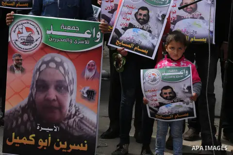 Palestinians hold placards during a protest in solidarity with Palestinian prisoners in Israeli jails, in front of high commissioner for human rights headquarters, in Gaza City on March 9, 2016. Photo by Mohammed Asad