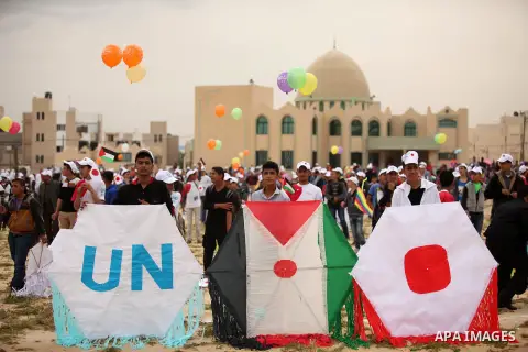 Palestinian children fly kites to show their solidarity with the Japanese people near the Japan-funded housing project in Khan Younis in the southern Gaza Strip March 13, 2016. The event was organised by the United Natio...