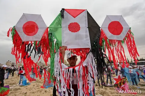 Palestinian children fly kites to show their solidarity with the Japanese people near the Japan-funded housing project in Khan Younis in the southern Gaza Strip March 13, 2016. The event was organised by the United Natio...