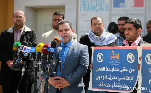 Palestinian journalists hold placards during a protest to solidarity with al-Aqsa TV channel which it removing from EUTELSAT, in Gaza City on March 14, 2016. Israeli Prime Minister Benjamin Netanyahu said Sunday that Isr...