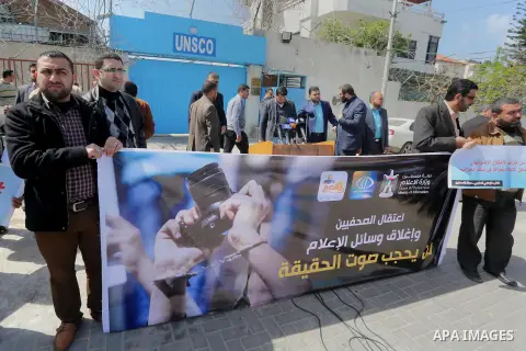 Palestinian employees of Al-Aqsa TV carry placards during a protest outside the United Nations Office in Gaza City on March 15, 2016, against the decision to halt transmission of the channel by the French satellite Eutel...