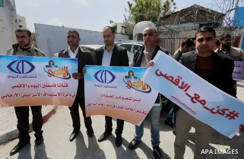 Palestinian employees of Al-Aqsa TV carry placards during a protest outside the United Nations Office in Gaza City on March 15, 2016, against the decision to halt transmission of the channel by the French satellite Eutel...