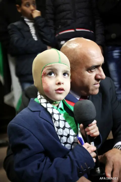 Five-year-old Ahmed Dawabsha, a Palestinian boy who survived a firebombing by Jewish extremists targeting his family home that killed his parents and brother, meets with the governor of the northern Palestinian town of N...