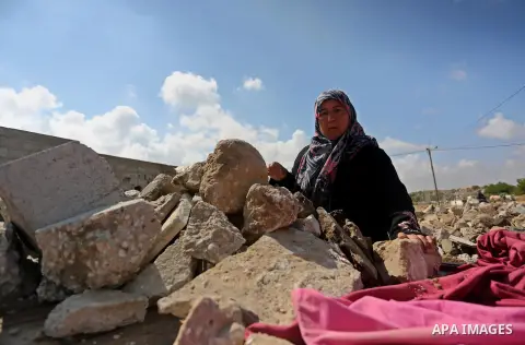 Palestinian woman Jihan Abu Muhsen collects bricks for sale with her son Mohammad from the ruins of a house destroyed during the 2014 war in Khan Younis in the southern Gaza Strip March 17, 2016. Abu Muhsen gathers brick...