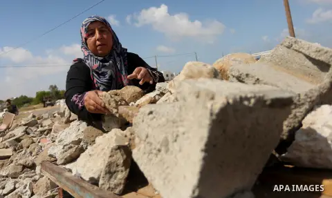 Palestinian woman Jihan Abu Muhsen collects bricks for sale with her son Mohammad from the ruins of a house destroyed during the 2014 war in Khan Younis in the southern Gaza Strip March 17, 2016. Abu Muhsen gathers brick...
