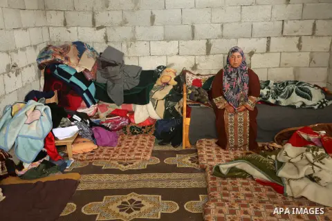 Palestinian woman Jihan Abu Muhsen sits inside her dwelling before going to work collecting bricks for sale from the sites of demolished buildings in Khan Younis in the southern Gaza Strip March 17, 2016. Abu Muhsen gath...