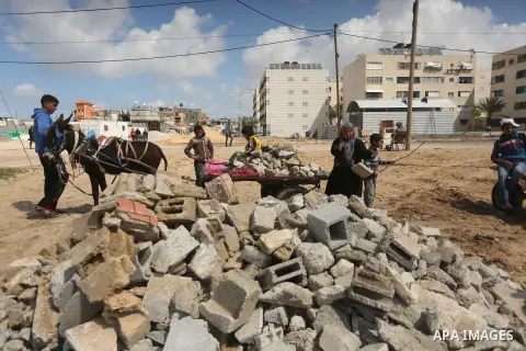 Palestinian woman Jihan Abu Muhsen collects bricks for sale with her son Mohammad from the ruins of a house destroyed during the 2014 war in Khan Younis in the southern Gaza Strip March 17, 2016. Abu Muhsen gathers brick...